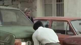 Franco Columbu lifts a car in Pumping Iron