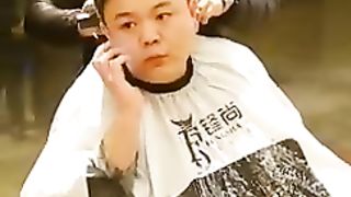 Barber watching a lady whilst shaving someone