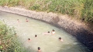 children swimming in the irrigation canal
