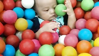 The child has a lot of balls piled up