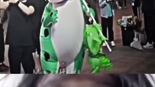 frog clown, who was standing in the corner of the room. He was wearing a green costume with a mask and boots. He looked very happy.