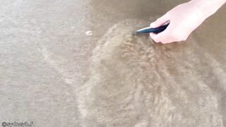 A man pulls out a worm from the beach.