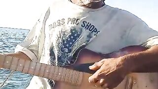 Funny man playing guitar in boat, entertainment
