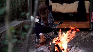 Girl at camp fire , relaxing