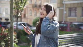 Young Woman Listening To Music And Walking In The City