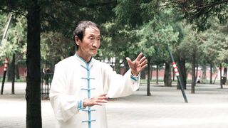 Slow Motion Footage Of A Man In Traditional Clothes Doing Tai Chi In A Park