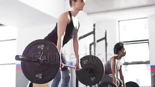 Woman lifting weights in fitness