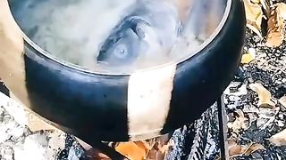 Cooking fish soup over a fire