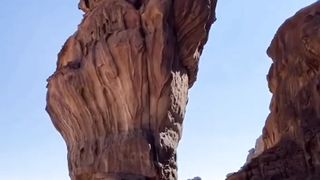 How this big rock is standing on the sand