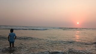 Playing in the waves on the beach at sunset