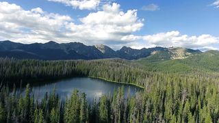 drone-flying-over-mountain-top-lake-4k