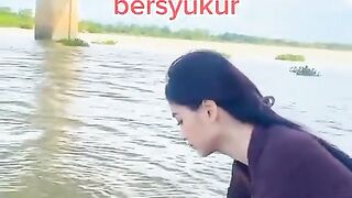 Beautiful girl is releasing fish in the river