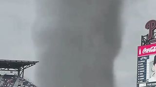 THIS IS TERRIBLE;GIANT TORNADO FLASHES LIGHTNING AND PASSES BY THE STADIUM