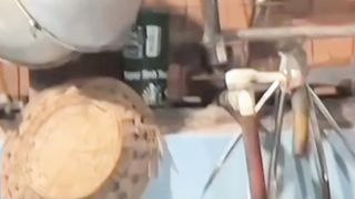 A cat is seen hiding in the kitchen
