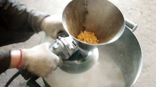 grinding corn on a grinder using a grinder