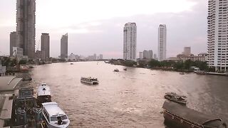 Sunset At Chao Phraya River With A View Of Boats And Skyscraper