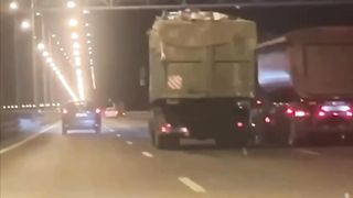 On the dam, a garbage truck made a garbage rain for cars passing nearby