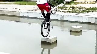 Bicyclists jumps over water