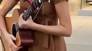 Karolina Protsenko talks to the crowd and plays guitar