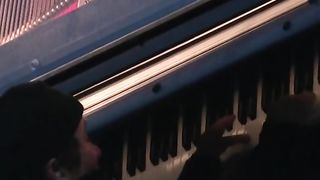 About 30 feet above the ground, Swiss pianist Alain Roche plays piano suspended vertically from a crane in Munich, Germany.