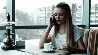 Woman talking on the phone in the coffee shop
