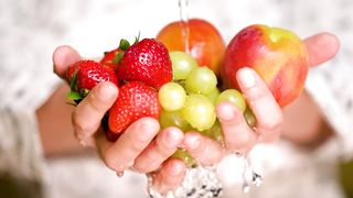 Rinsing strawberries, apples and grapes holding hands