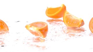 Orange slices falling into water