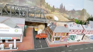 Giant Cat Attacks Car on Model Train Set.
