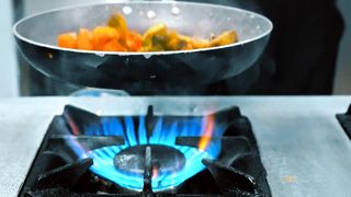 Chef cooking stir fry vegetables on high heat