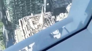 Random bloke climbs up skyscraper and passes a office while people inside stare at him with amazement.