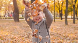 Happy child playing with autumnal