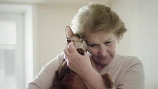 Old woman hugging her cat