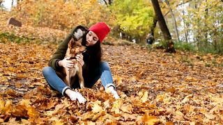 Girl stroking her dog in nature in autumn