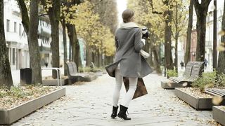 Happy woman walking with shopping bags at autumn