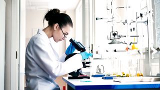 Female scientist observing through a microscope