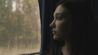 Nostalgic girl looking thru a window bus