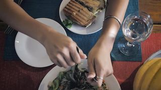 Woman eating salad and sandwich
