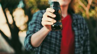 Two friends doing cheers with soda