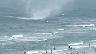 Footage captures waterspout ripping through crowded beach