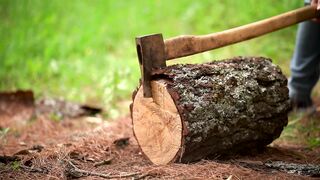 Man splitting a piece of log with an ax