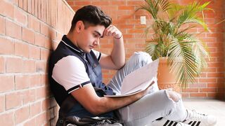 Frustrated student at his school studying his notes