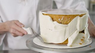 Expert pastry chef covering a cake with icing