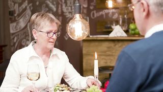 Senior woman chats over romantic dinner in modern restaurant