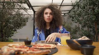 Portrait of a woman eating pizza at lunch