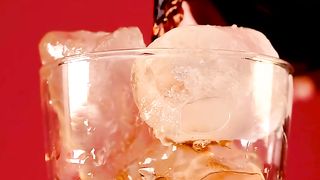 Filling a glass with soda from a bottle