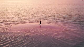 Sandbar island in the middle of the sea at sunset