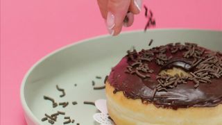 Spreading Chocolate Chunks on a Glazed Donut