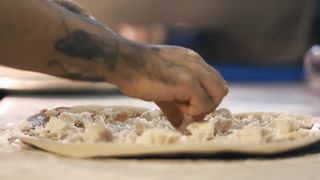 Chef putting ingredients for a pizza