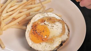 Burger being prepared with french fries