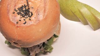 Burger and a sliced pear on a plate